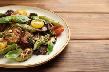 Delicious salad with grilled vegetables on wooden table, closeup. Space for text