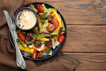 Delicious salad with grilled vegetables served on wooden table, flat lay. Space for text