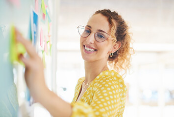 Happy woman, business and schedule planning with whiteboard for brainstorming, ideas or reminder at office. Female person, planner or employee with smile for notes, mission or priority at workplace © TasJam/peopleimages.com