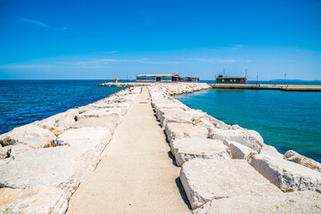Fototapeta premium A view along the top of the harbour breakwater at Rimini, Italy in summertime