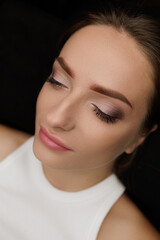 Fototapeta premium The result of the work done permanent eyebrow makeup for a brunette who looked down. Permanent eyebrow makeup PMU for brunettes