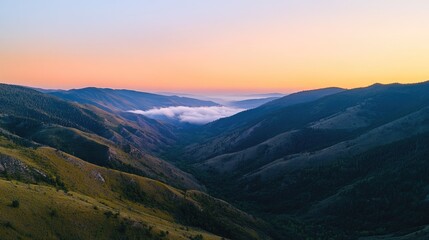 Overhead shot of a mountain valley at sunrise, with clear sky for copy