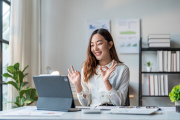 Young businesswoman making ok sign gesture during video call with tablet in office
