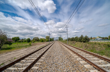 Tory kolejowe pod spektakularnie pięknym epickim niebem. Piękny wiosenny dzień w południe na obrzeżach miasta (Ostrowiec) tory kolejowe prowadzące w kierunku Sandomierza. © Grzegorz