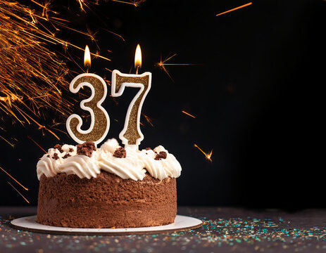 Birthday cake with 37 years birthday candle on dark background with sparklers. copy space.