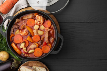 Tasty homemade stew with vegetables and bread on grey wooden table, flat lay. Space for text