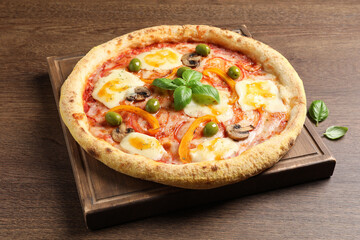 Delicious vegetarian pizza with fresh basil on wooden table