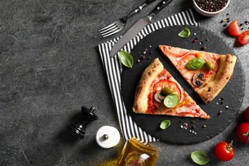 Cut delicious vegetarian pizza, cutlery and ingredients on grey table, top view. Space for text