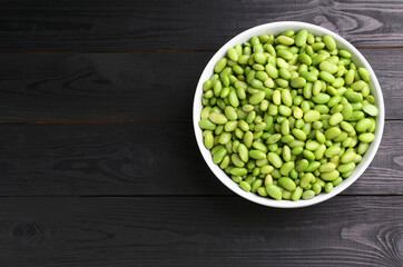 Raw green edamame soybeans on wooden table, top view. Space for text