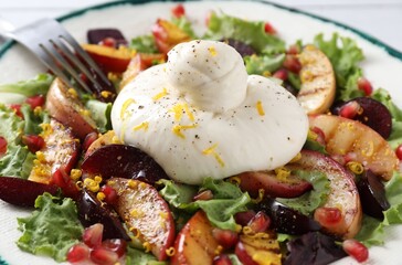 Fresh burrata salad with spices on plate, closeup