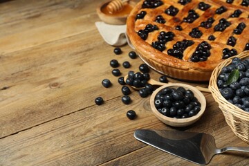 Tasty homemade pie with blueberries served on wooden table. Space for text