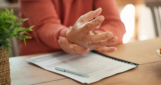 Senior man, hands and wrist pain from writing, pressure or strain with injury, arthritis or Parkinson at home. Closeup of mature male person in sore joint, inflammation or ache with form or documents