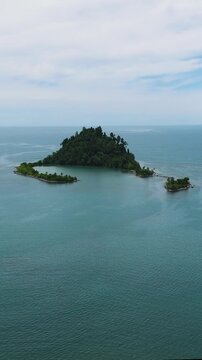 Beautiful Cabugao Island in letter C formation with green trees. Mindanao, Philippines. Vertical view.