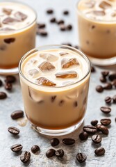 Iced coffee drinks served in clear glasses with coffee beans scattered on a textured surface