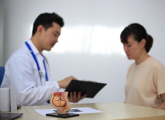 Fototapeta premium Male doctor with experience examining young pregnant women