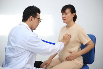 Obraz premium Male doctor with experience examining young pregnant women
