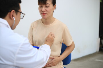 Obraz premium Male doctor with experience examining young pregnant women