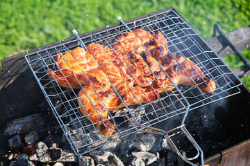 Chicken, tabaka chicken, grill barbecue meat on a brazier with smoke, green grass background