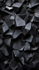 Dark geometric basalt rock formations creating natural stone wall