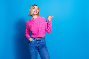 Portrait of nice young woman look direct finger empty space wear pink sweater isolated on blue...