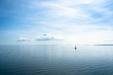 Sailboat against a dreamy blue sea and sky. Photo taken on the Baltic Sea with distant views of Hiiumaa Island, Estonia