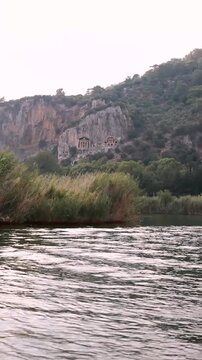 View of the Lycian tombs from the water in Dalyan, T&uuml;rkiye.