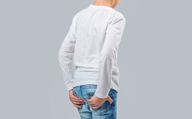 Health concept. Child boy standing with holding her butt having hemorrhoids or rhypophobia, feel...