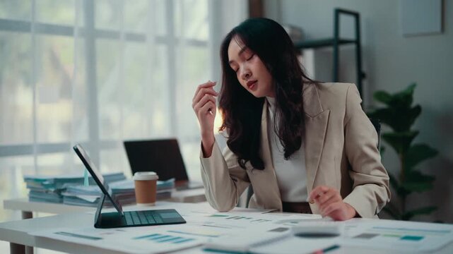 Businesswoman overwhelmed with paperwork, dealing with stress and fatigue at her desk in a modern office, highlighting the challenges and pressures of a corporate job