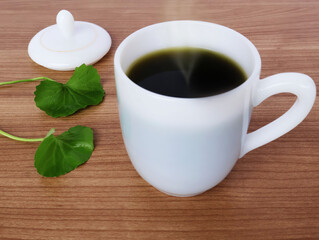 Dark green water in a pearl cup with a handle. Place the Centella asiatica leaf and lid next to it on the wooden table.

ไอคอนยืนยันโดยชุมชน