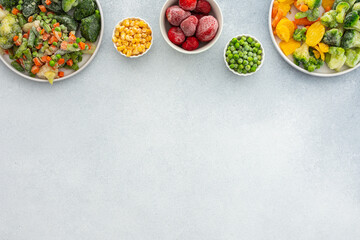 Preparing fresh vegetables in summer for winter, various frozen vegetables and berries in plates on...
