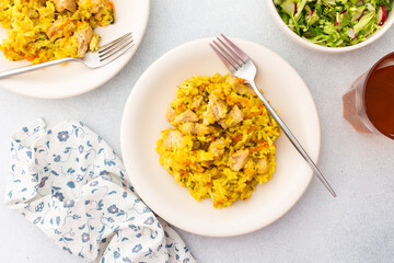 Stewed rice with chicken breast and mixed salad with radishes and various seeds, a served table with food, a delicious hearty lunch or dinner
