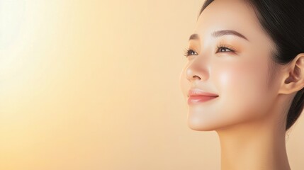 Fototapeta premium Elegant Asian woman with glowing skin, captured on a beige background, perfect for promoting facial care, cosmetology, and spa services