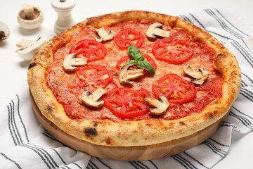 Delicious pizza with tomatoes, mushrooms and basil on table, closeup