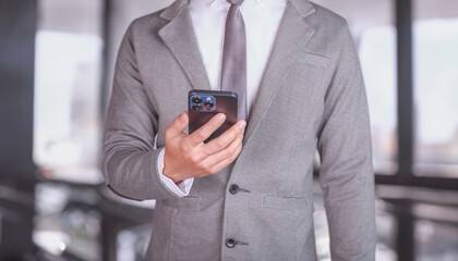Businessman using smartphone in office. Corporate communication and modern technology concept. Professional networking and digital interaction in business environment
