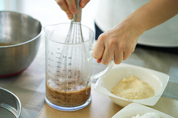 Hands mixing cake dough to make banana cakes that are smooth, sweet, and delicious