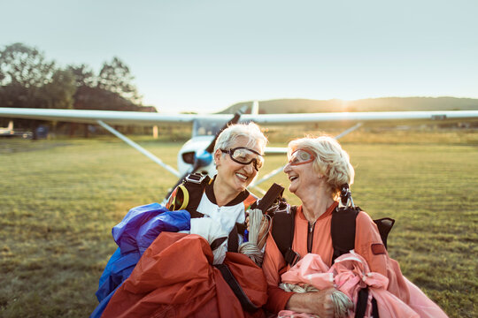 Portrait of a two happy senior women smiling after skydiving