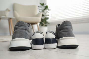 Big and small sneakers on floor indoors