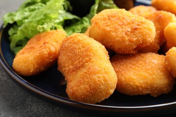 Tasty chicken nuggets on grey table, closeup