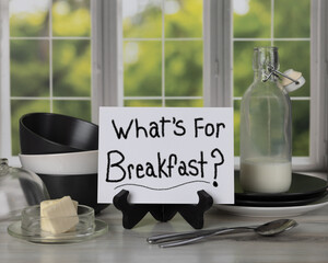 What's for Breakfast? Sign sitting on easel in front of kitchen window with jar of milk butter...