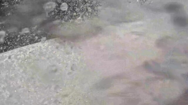 An unrecognizable man records himself with an aquatic camera going down a slide in a water park. Water parks concept. Attractions on the water.