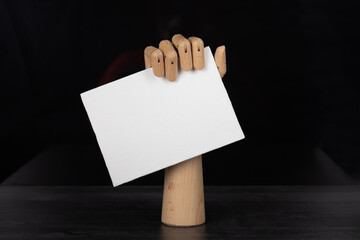 Empty blank sign being held by wooden jointed manikin hand.

