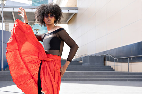 Young dancer posing with red skirt flowing in the wind