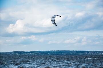 Minsk, Belarus - June 15, 2014. Kitesurfing. One kite in the sky and man on water. The concept of sports, health, recreation. Holidays on nature. Activity lifestyle. Windy weather. Lake entertainment