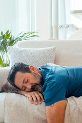 Adult man taking a restful nap at home during the day, showing signs of exhaustion or laziness...