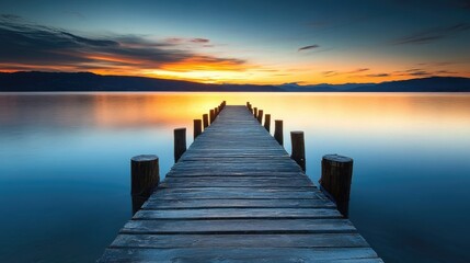 Naklejka premium Wooden pier extending over calm water at sunset. background with beautiful landscape