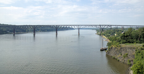 Fototapeta premium view of walkway over the hudson railroad bridge pedestrian and cycling path across river (distance far away boat) traffic view scenic walking trail high up
