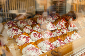 Close up of tray of freshly baked pastries, flavorful, warm, crispy gourmet croissants with powdered sugar, berry and cream. Bakery recipes. Concept of food, bakery, cuisine, desserts, cooking and