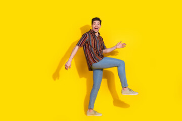 Full length portrait of nice young man walk empty space wear shirt isolated on yellow color background