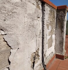  old cracked concrete wall, Isolated. concrete wall with cracks, peeling layers of cement, concrete  on the balcony. 