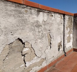 old cracked concrete wall, Isolated. concrete wall with cracks, peeling layers of cement, concrete on the balcony.